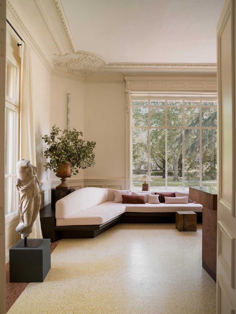 Denní zóna s rohovou sedačkou, vysokými okny a výhledem do zahrady