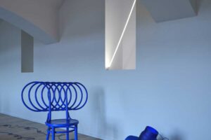 Interiér bytu s obloukovým stropem a výrazným barevným nábytkem v historickém domě po rekonstrukci