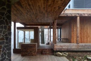 Zastřešená dřevěná terasa přístavby na Medníku citlivě zasazená do svažitého terénu