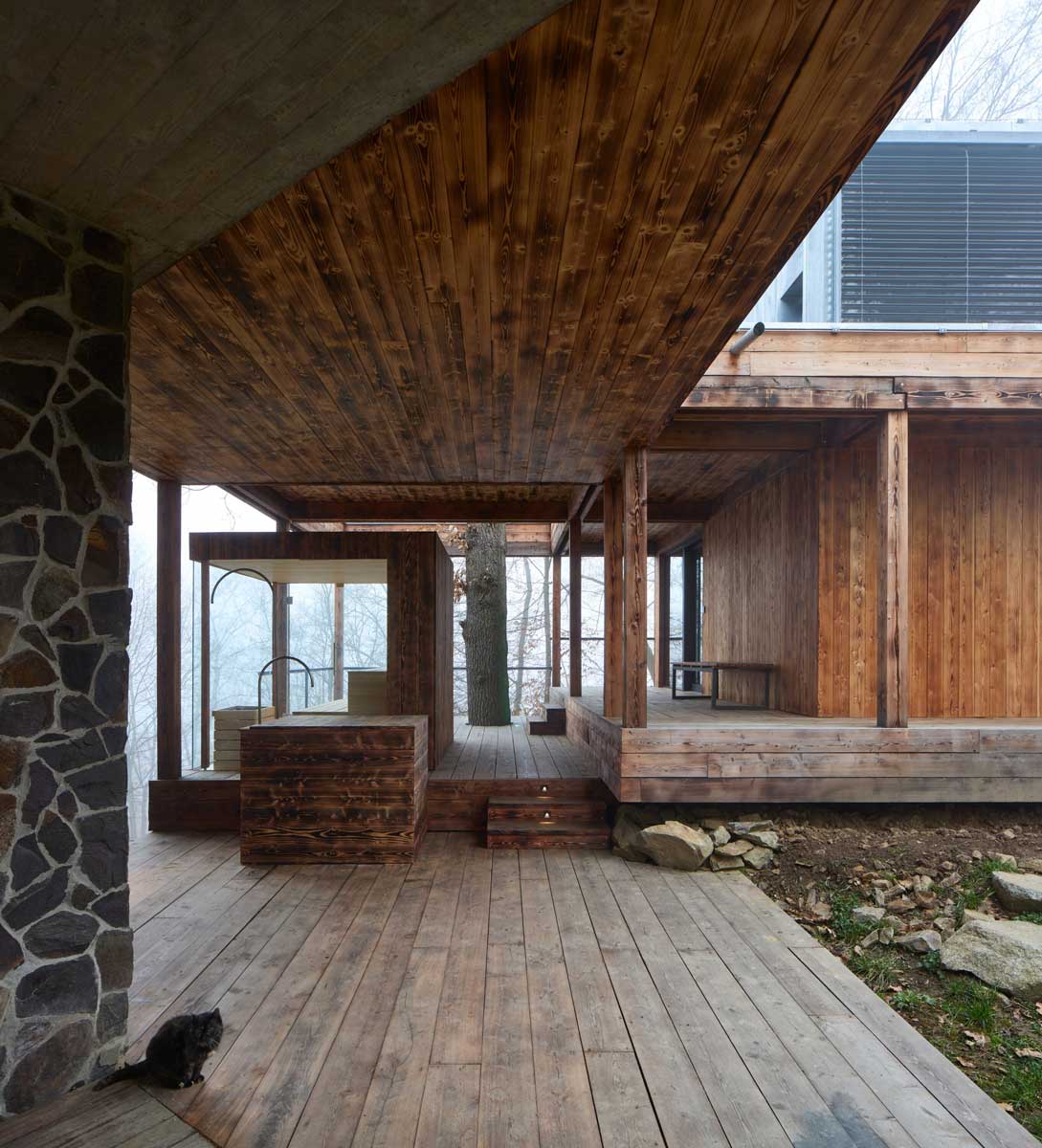 Zastřešená dřevěná terasa přístavby na Medníku citlivě zasazená do svažitého terénu