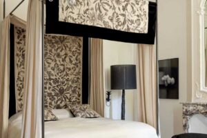 Elegantní ložnice s krbem, křesly a tlumenou barevnou paletou