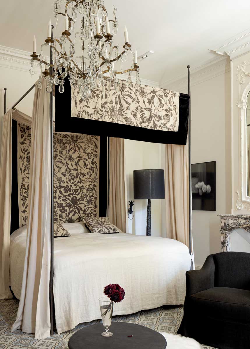 Elegantní ložnice s krbem, křesly a tlumenou barevnou paletou