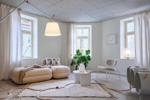 Obývací prostor v bytě s odhaleným betonovým stropem a důrazem na jednoduchost a klidnou atmosféru