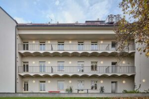 Pohled do vnitrobloku rekonstruovaného pavlačového domu s nově pojatými pavlačemi a světlou fasádou