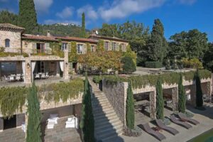 Exteriér historického domu Brigitte Bardot na Riviéře obklopený zelení a kamennými zdmi