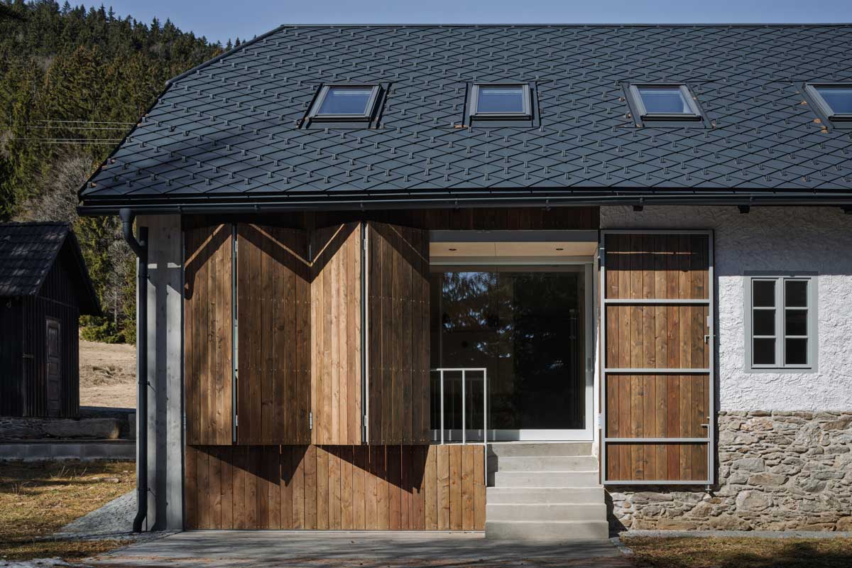 Rekonstruovaná stodola s velkými dřevěnými vraty a novým prosklením