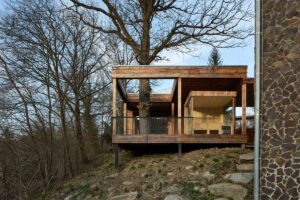 Přístavba Domu Medník umístěná na okraji lesa mezi stromy