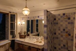 Barevná koupelna v historickém sídle Brigitte Bardot s mozaikovými obklady a vintage detaily