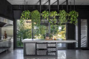 Profesionální BBQ-zóna kombinuje beton, nerezovou ocel a zeleň a plynule přechází do zahrady