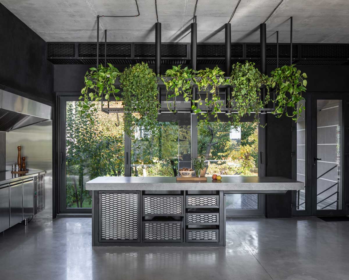 Profesionální BBQ-zóna kombinuje beton, nerezovou ocel a zeleň a plynule přechází do zahrady