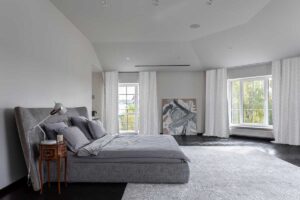 Hlavní ložnice v domě Ridnyj ve světlých tónech s velkorysým prostorem a klidnou atmosférou