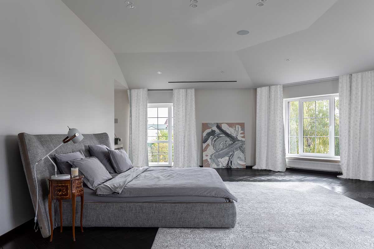 Hlavní ložnice v domě Ridnyj ve světlých tónech s velkorysým prostorem a klidnou atmosférou