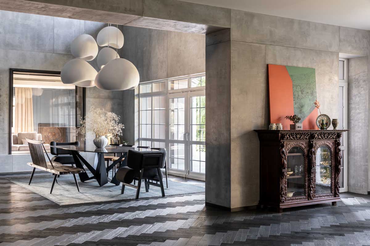 Jídelna v domě Ridnyj jako otevřený dvoupodlažní prostor s výraznými designovými svítidly