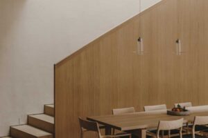 Jídelní stůl z masivního dřeva umístěný v otevřeném obytném prostoru rodinného domu