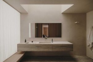 Minimalistická koupelna s kamenným umyvadlovým blokem a jemným denním světlem v rodinném domě v Paříži