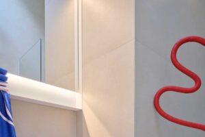 Moderní koupelna v pavlačovém domě s čistými liniemi výrazným barevným detailem a důrazem na funkčnost