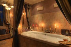 Luxusní koupelna v historickém domě Brigitte Bardot s vanou, svíčkami a atmosférou provensálského glamouru