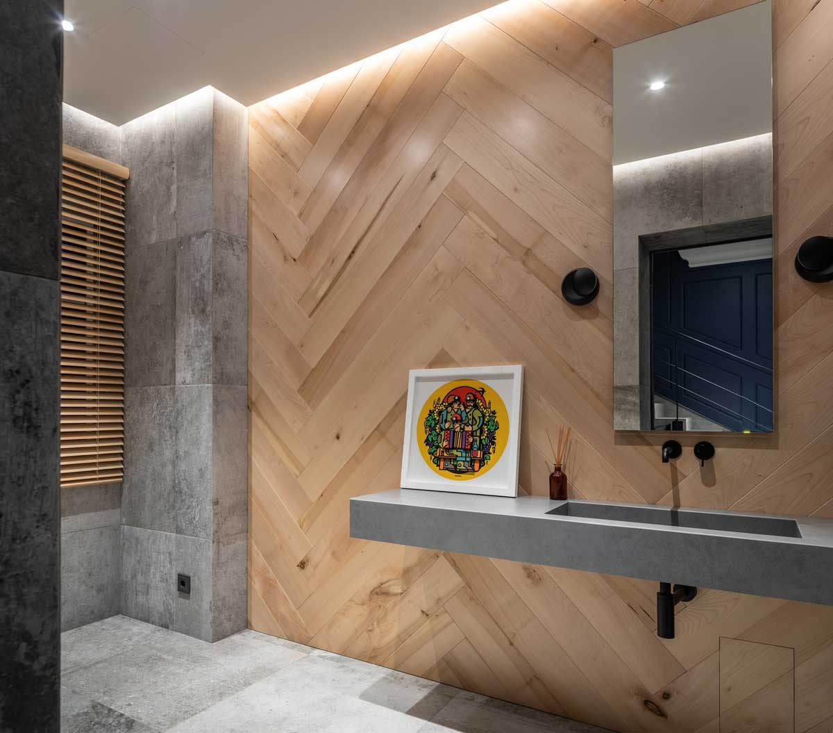 Koupelna s betonem, dřevěným obkladem a minimalistickým umyvadlem