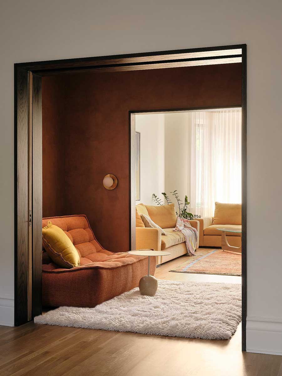 Relaxační křeslo v obytné části domu s teplými barvami, textiliemi a měkkým světlem