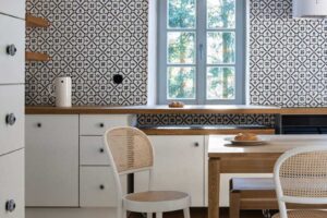 Kuchyně v chalupě s tradičními skříňkami vzorovaným obkladem a dřevěnou pracovní deskou