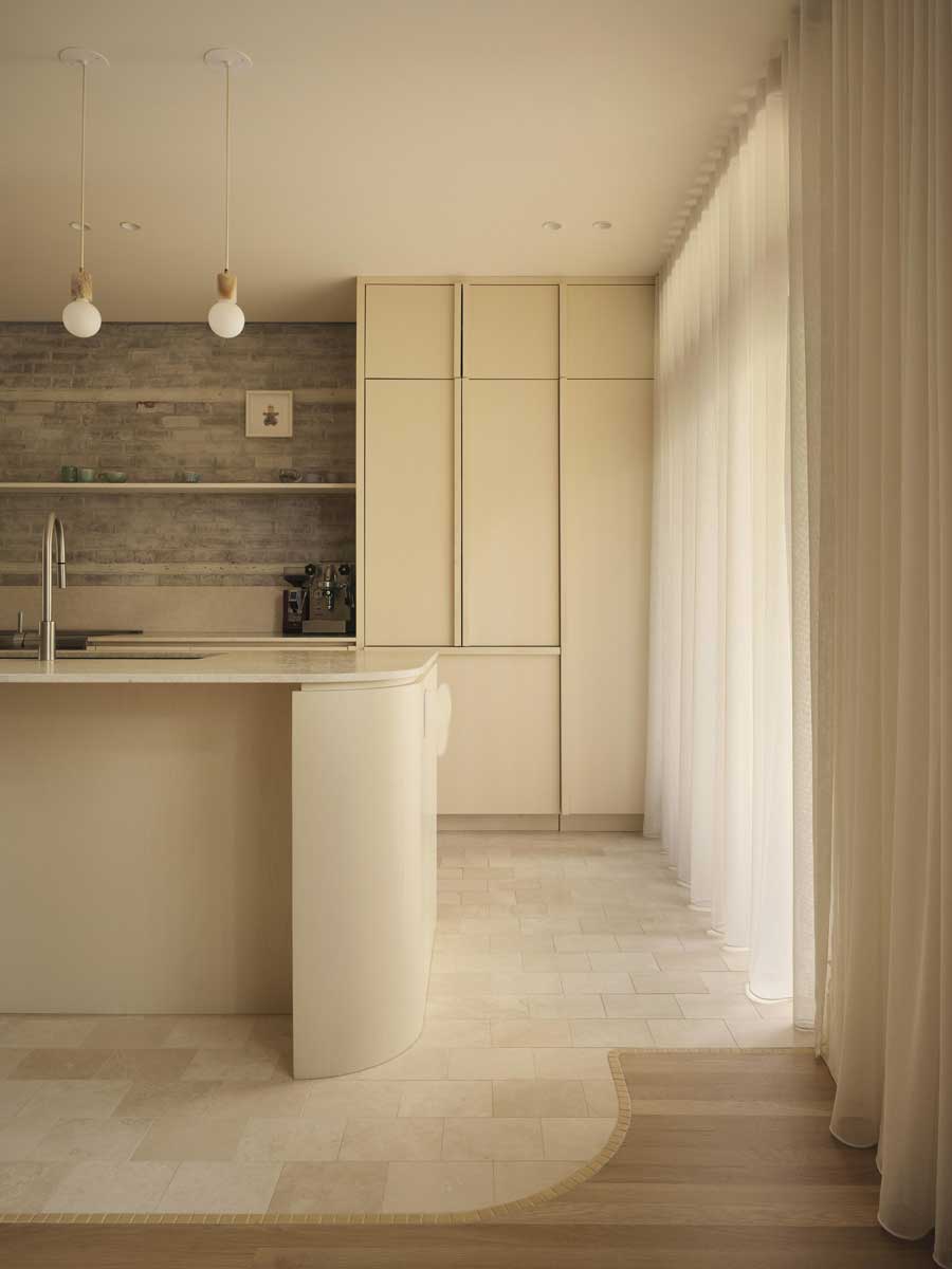 Moderní kuchyně v rodinném domě s oblým ostrůvkem, světlými povrchy a minimalistickým řešením