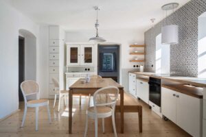 Kuchyně s jídelnou v chalupě s dubovým stolem světlým nábytkem a historickými prvky