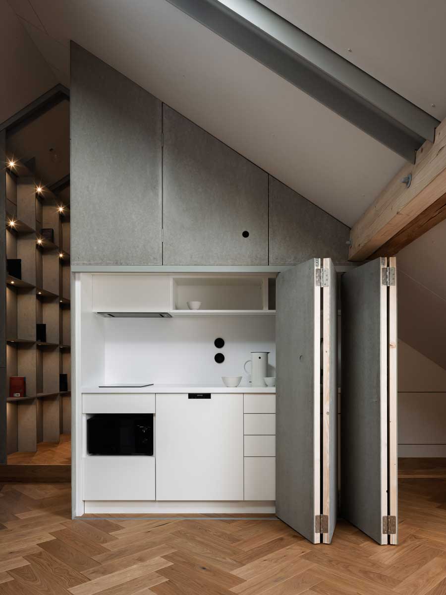 Kuchyňská vestavba skrytá za posuvnou stěnou z vláknocementových desek