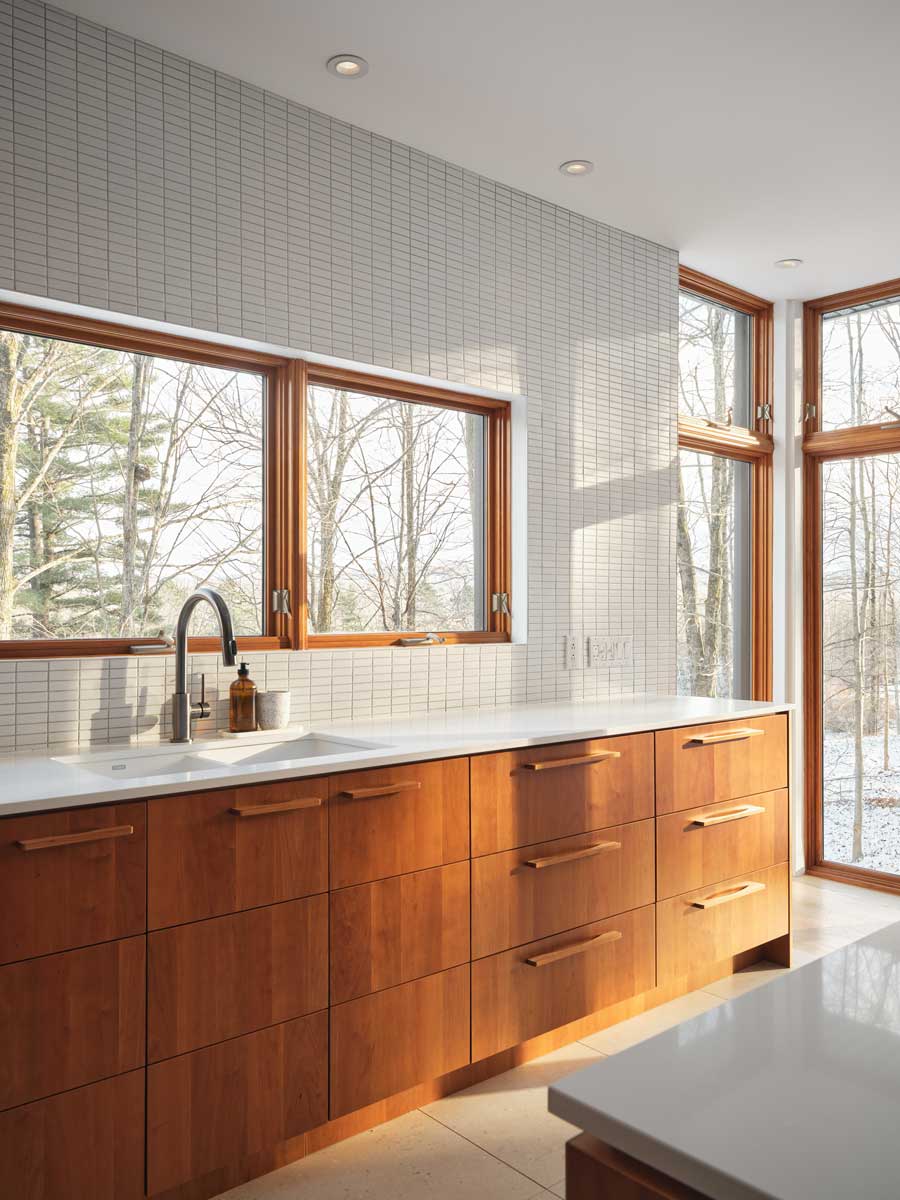 Kuchyňská linka v kombinaci dřeva a světlých ploch respektuje původní architekturu domu