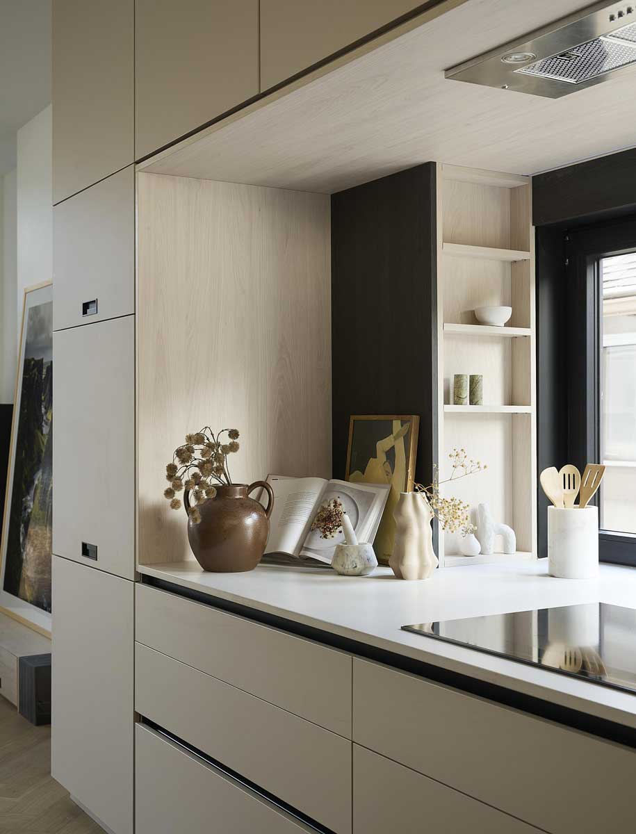 Detail kuchyňské linky s vestavěnými skříňkami a otevřenými policemi
