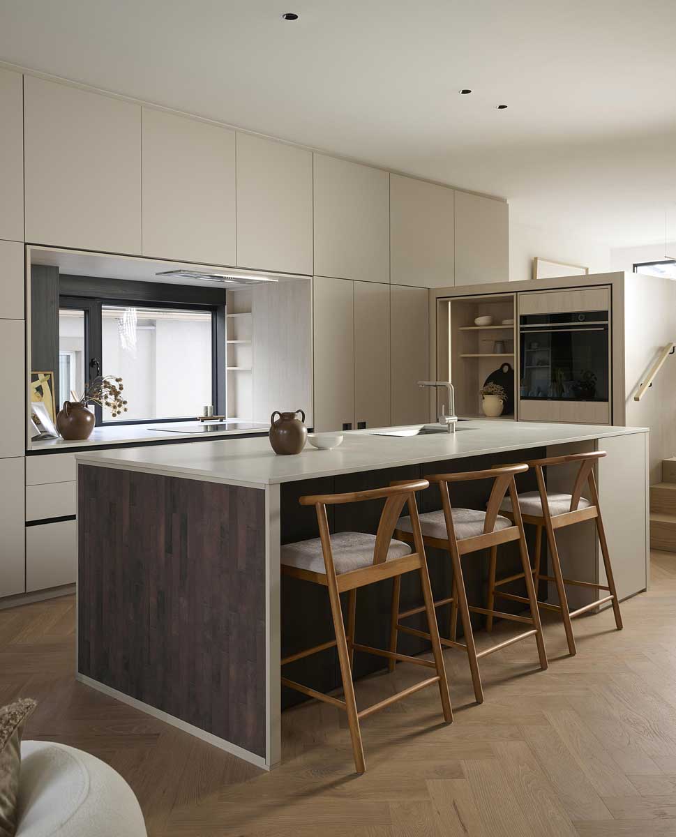 Kuchyňský ostrůvek s barovými židlemi v otevřeném interiéru