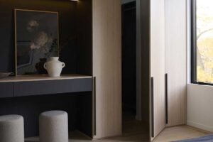 Ložnice s vestavěnými dubovými skříněmi, jemnou barevností a výhledem do korun stromů