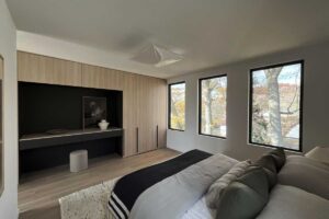 Celkový pohled na hlavní ložnici s vestavěným úložným systémem a velkými okny