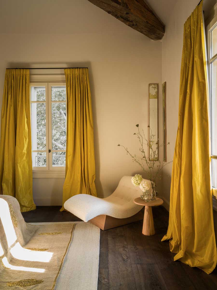 Ložnice se žlutými závěsy, relaxačním lehátkem a přírodními materiály