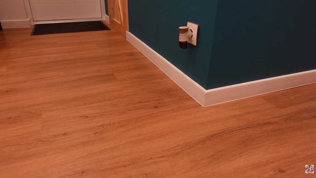 Jednotná vinylová podlaha v bytě s bílými podlahovými lištami