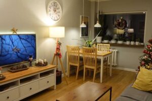 Obývací pokoj v zrekonstruovaném panelákovém bytě s jídelním stolem a vánoční výzdobou