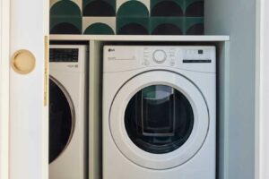 Prádelna s dekorativním obkladem v zelených tónech a vestavěnými spotřebiči