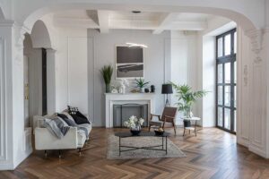 Světlý obývací prostor s výraznými oblouky a klasickými parketami propojující historickou architekturu s moderním bydlením