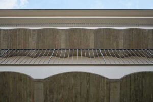 Detail pavlačí s klenutým stropem a subtilním zábradlím v rekonstruovaném pavlačovém domě v Nuslích