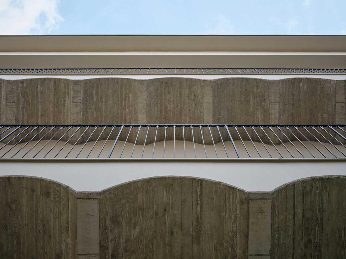 Detail pavlačí s klenutým stropem a subtilním zábradlím v rekonstruovaném pavlačovém domě v Nuslích