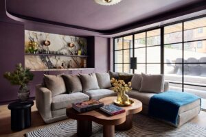 Obývací pokoj s velkou pohovkou, konferenčním stolkem a prosklenou stěnou