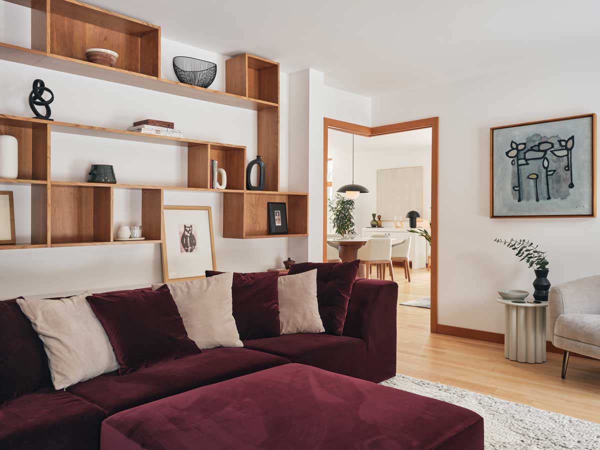 Obývací pokoj propojuje vestavěný nábytek, umění a otevřený pohled do dalších částí domu.