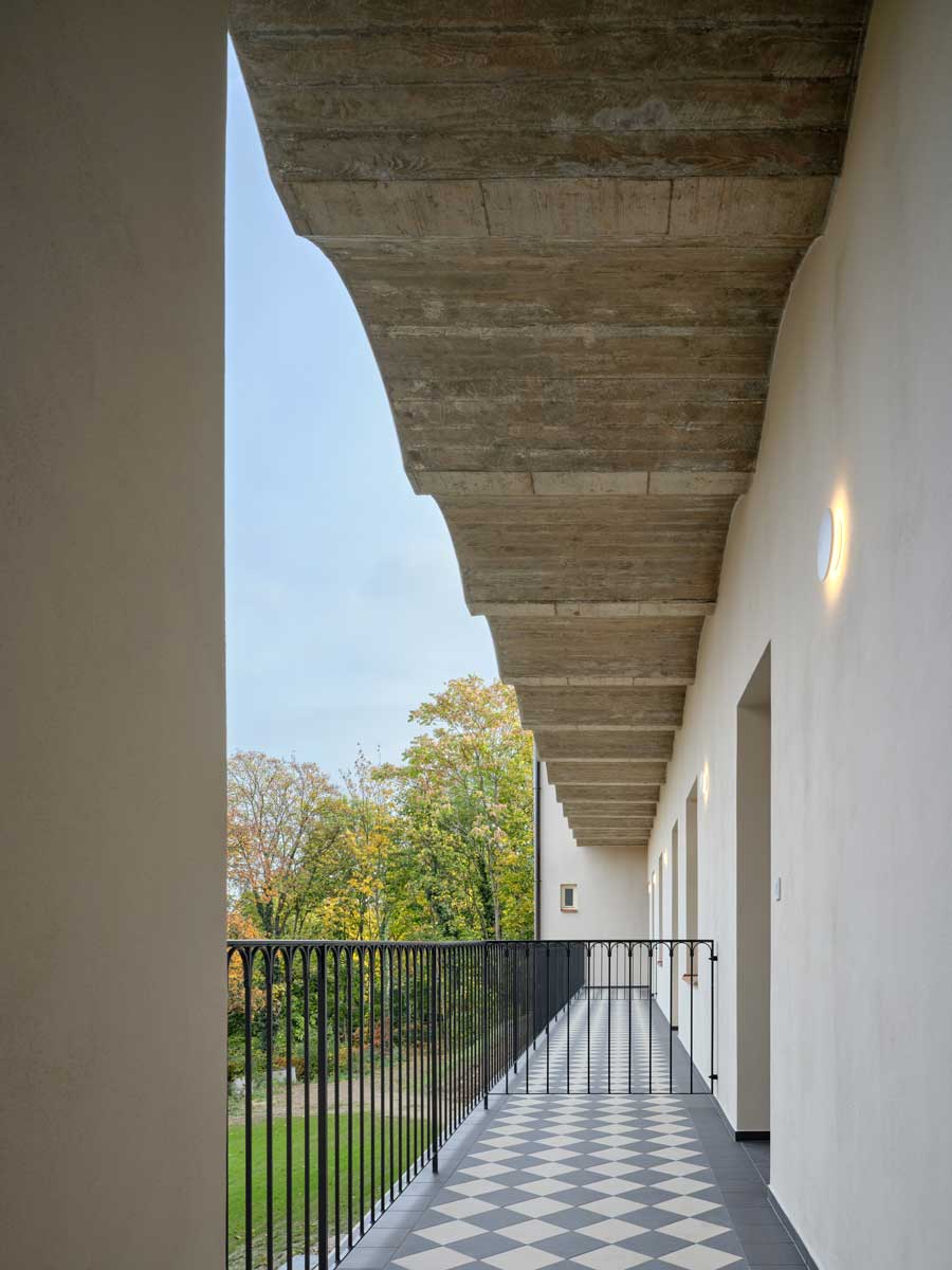 Pavlače pavlačového domu přetvořené na polosoukromé balkony s šachovou keramickou dlažbou