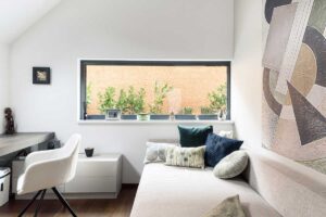 Pracovna s vestavěným pracovním stolem, čalouněným sezením a přirozeným denním světlem.