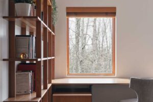 Pracovní stůl u okna využívá denní světlo a propojuje interiér s okolní zelení