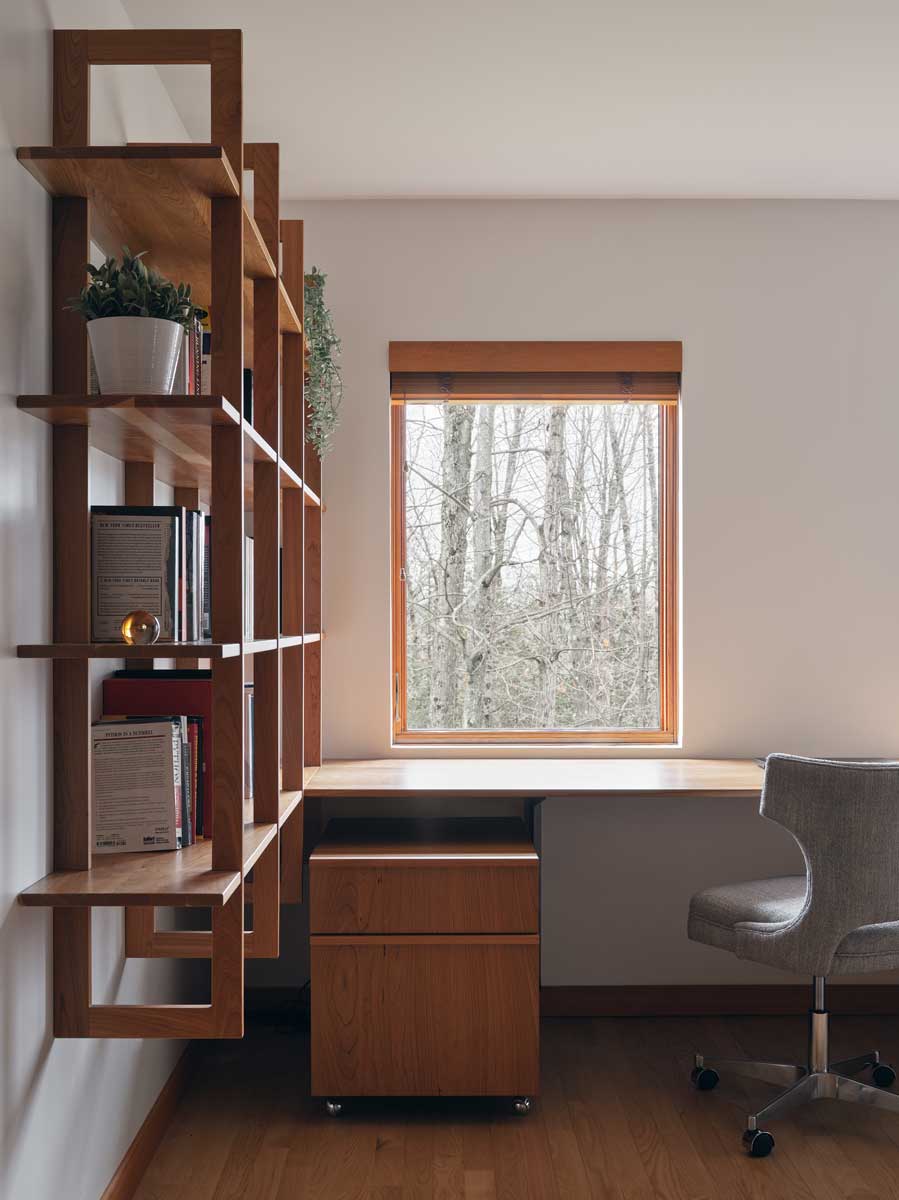 Pracovní stůl u okna využívá denní světlo a propojuje interiér s okolní zelení