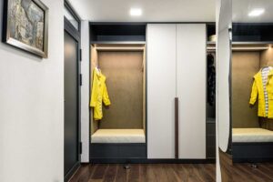 Předsíň s vestavěnou skříní, čalouněným sezením a integrovaným osvětlením.