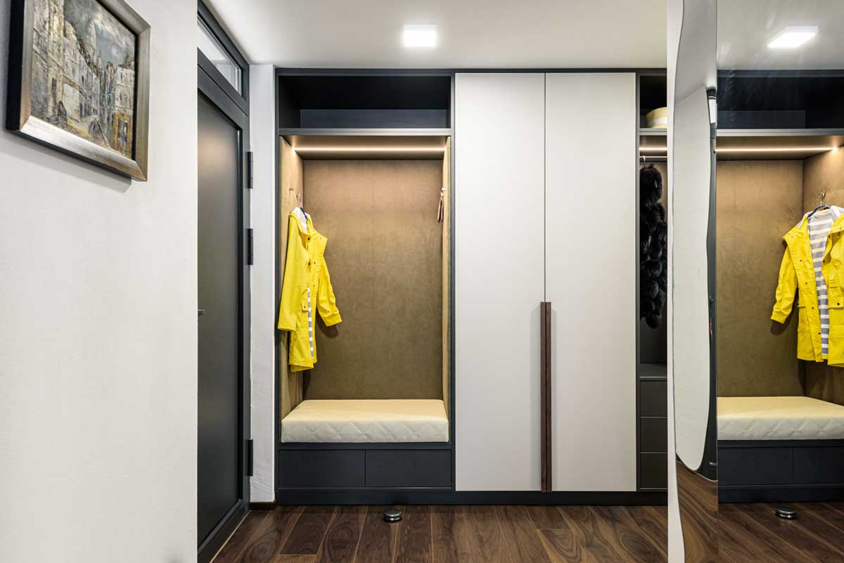 Předsíň s vestavěnou skříní, čalouněným sezením a integrovaným osvětlením.