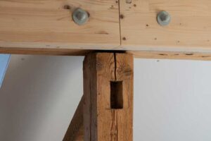 Detail propojení původního dřevěného trámu s novou ocelovou a dřevěnou konstrukcí