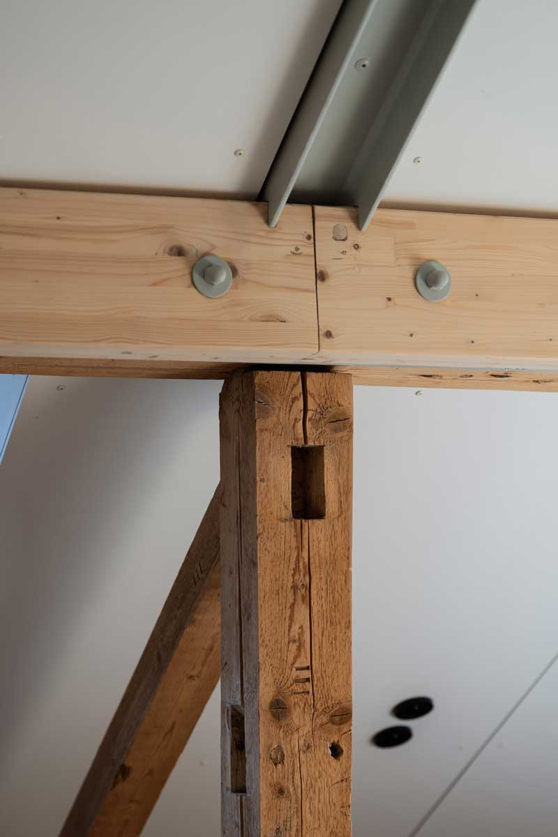 Detail propojení původního dřevěného trámu s novou ocelovou a dřevěnou konstrukcí