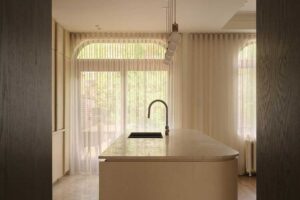 Kuchyňský ostrůvek s oblými hranami a světlou pracovní deskou v otevřeném prostoru